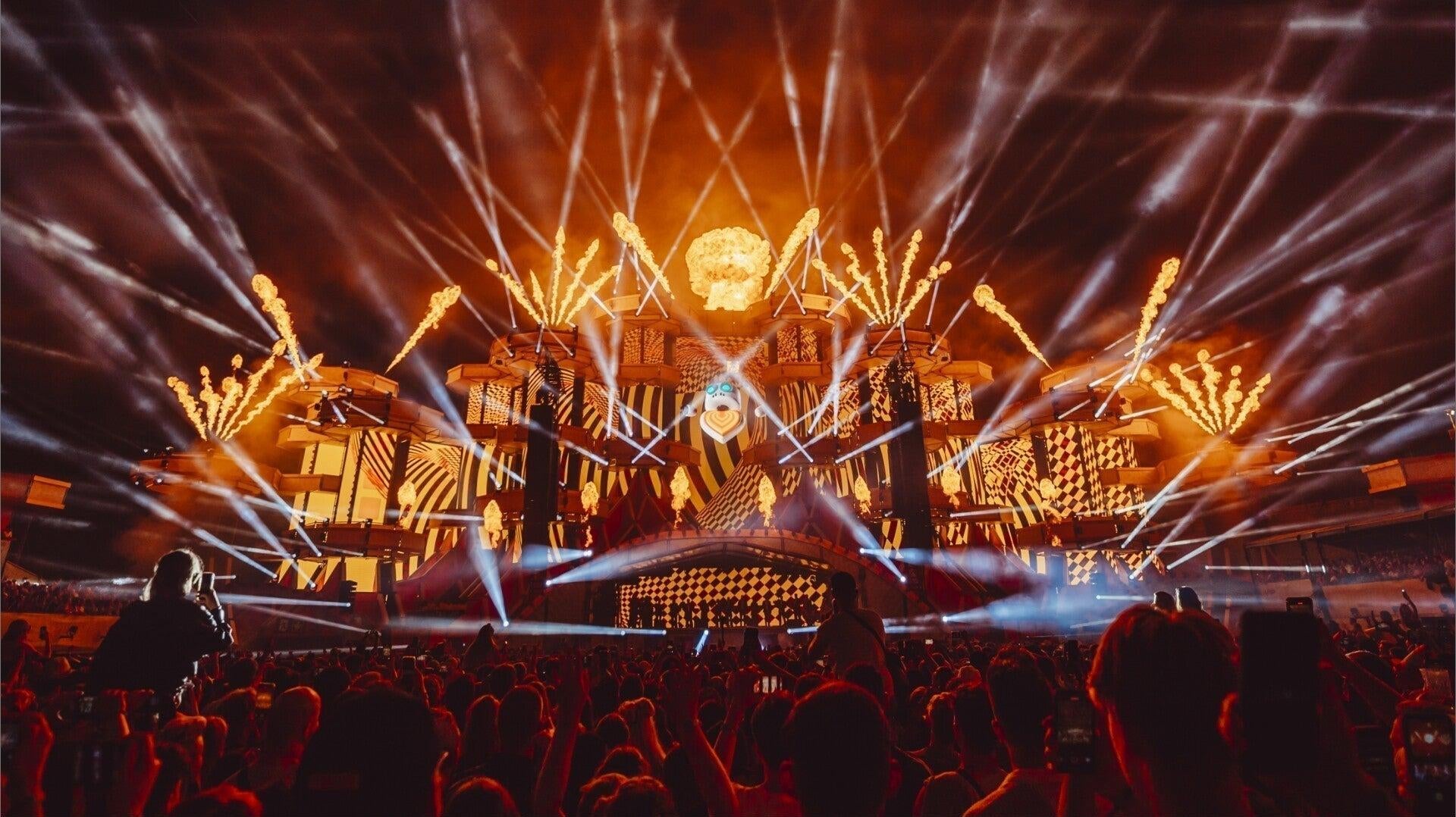Electric Love Festival main stage with dazzling orange lights, fireworks, and a massive crowd.