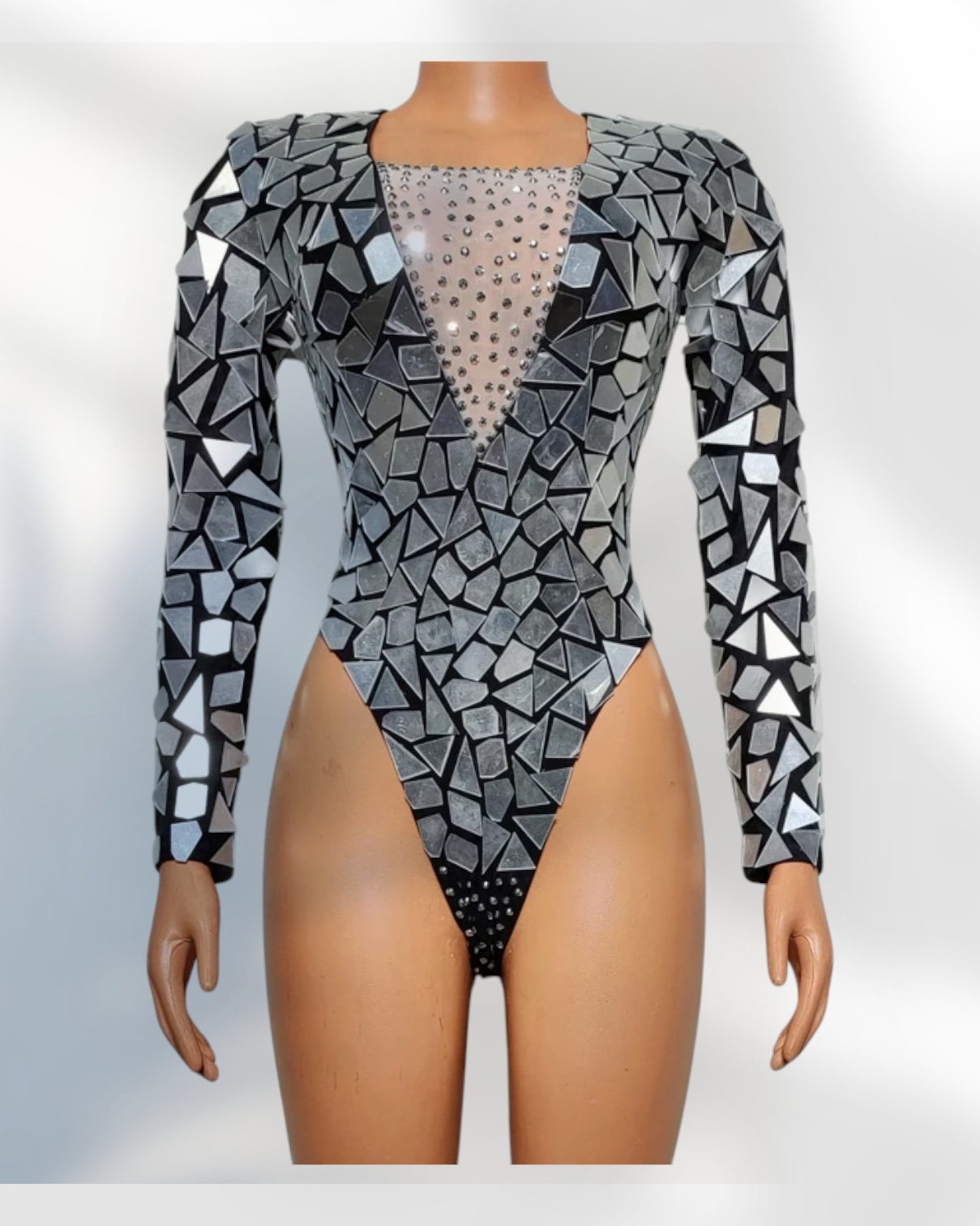 Mannequin wearing a patterned long-sleeve top with geometric design on a white background