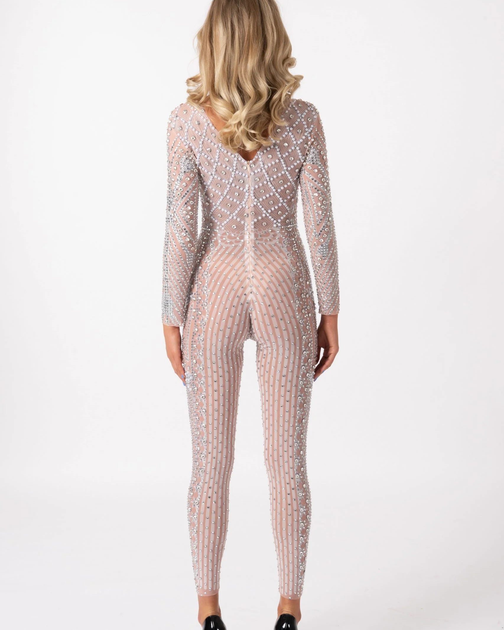 Back view of a nude, long-sleeve jumpsuit featuring hand-glued rhinestones in a vertical striped pattern on stretch fabric.