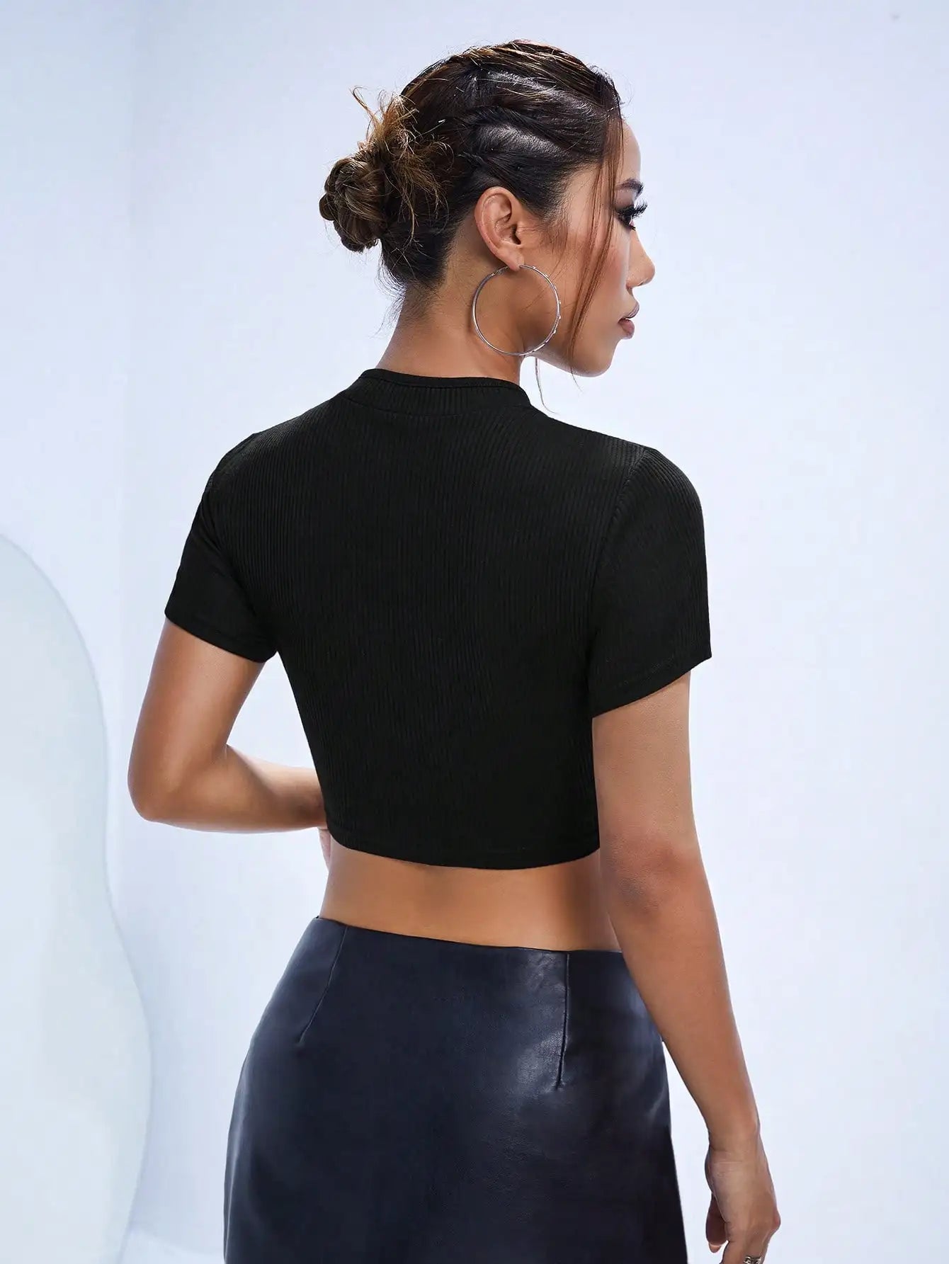 schwarzes Crop-Top mit Schlüssellochausschnitt, Rückansicht, hebt das Schlüsselloch-Detail und das gekürzte Design hervor