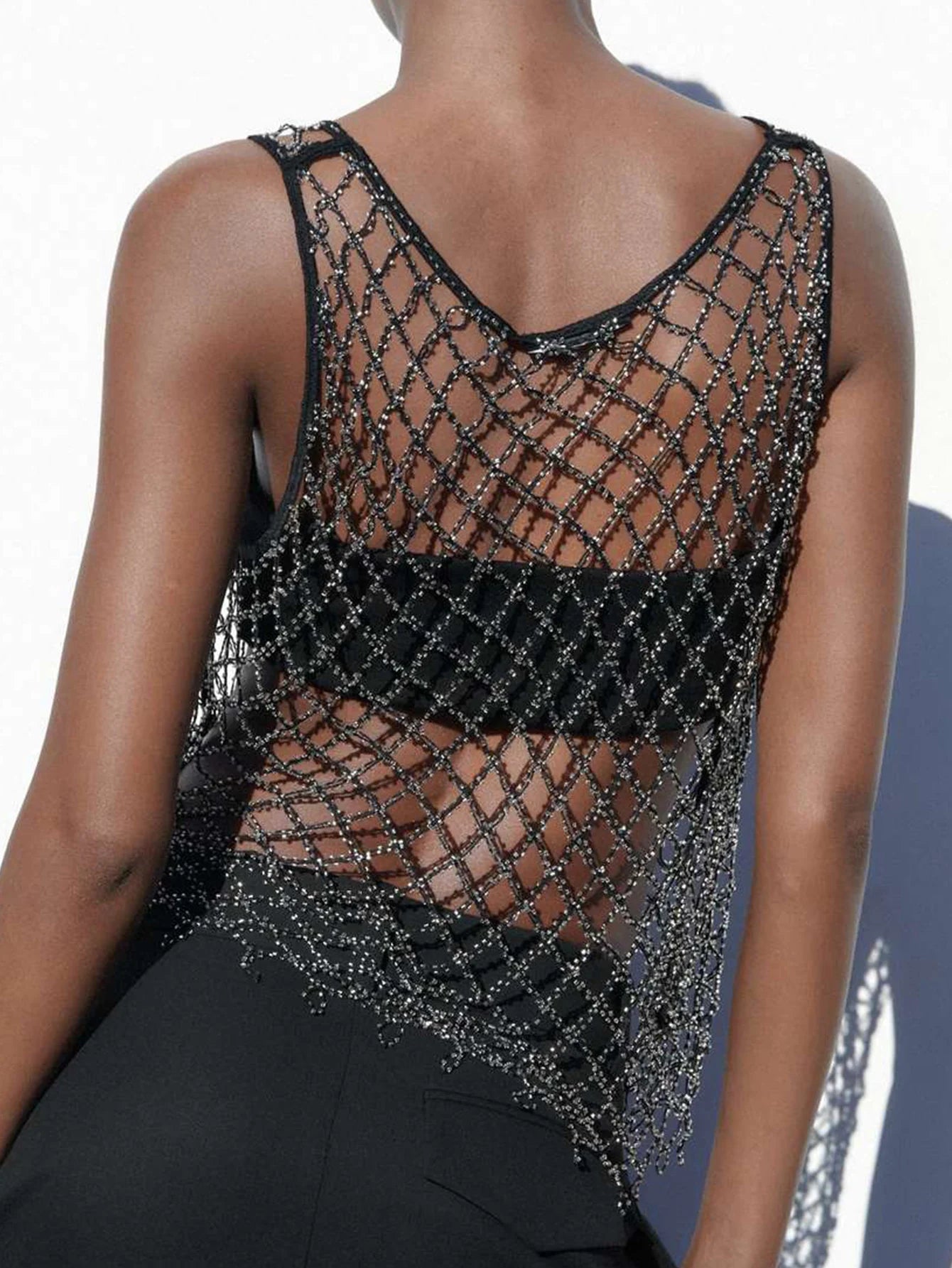 Débardeur noir en mesh transparent avec détails en strass, parfait pour la mode des festivals.