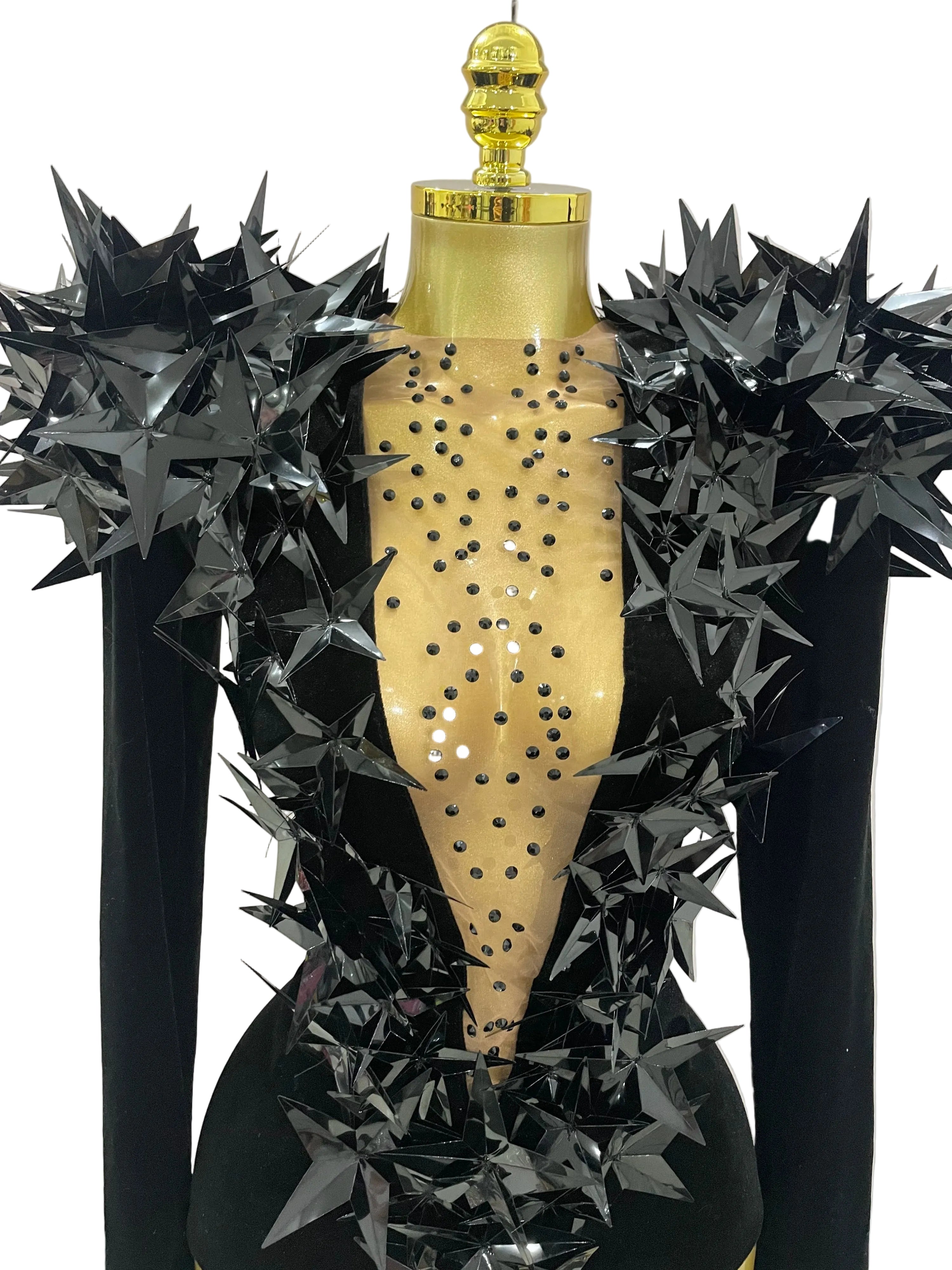 vue rapprochée du justaucorps en velours noir orné de strass avec des embellissements audacieux en forme d'étoile