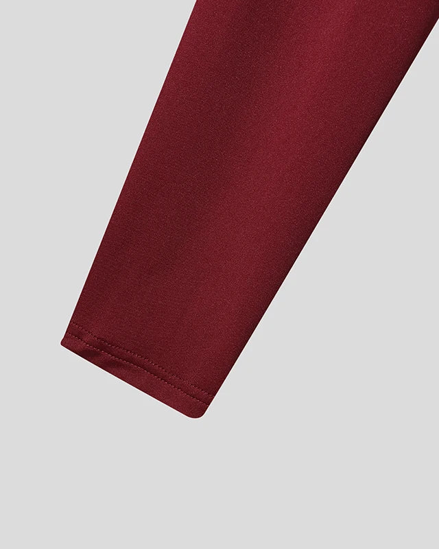 gros plan sur la manche courte à franges de pompons en tissu extensible bordeaux