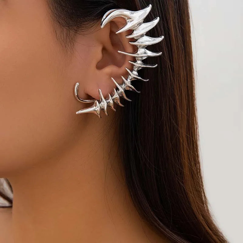 Ear cuff in metallo argento Cyberpunk, un avvolgimento completo dell'orecchio con punte biomeccaniche appuntite e angolari a forma di spina.