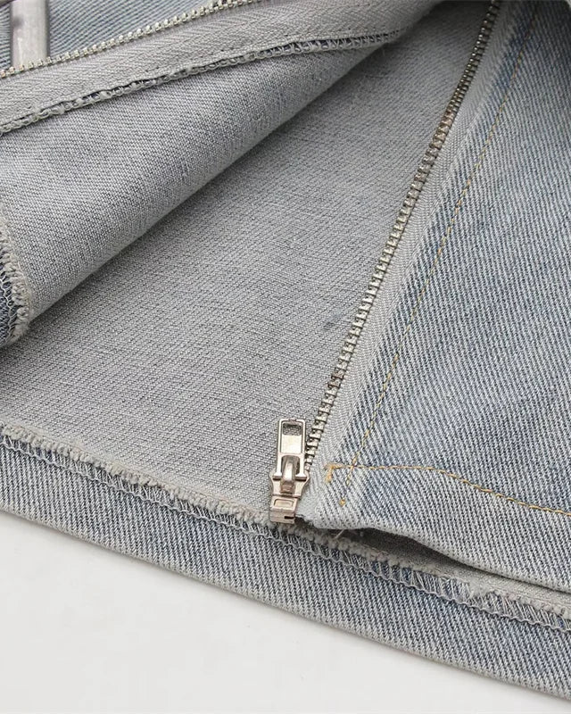 Close-up of the zipper detail of Cross Belt Denim Mini Skirt, showcasing quality denim fabric.