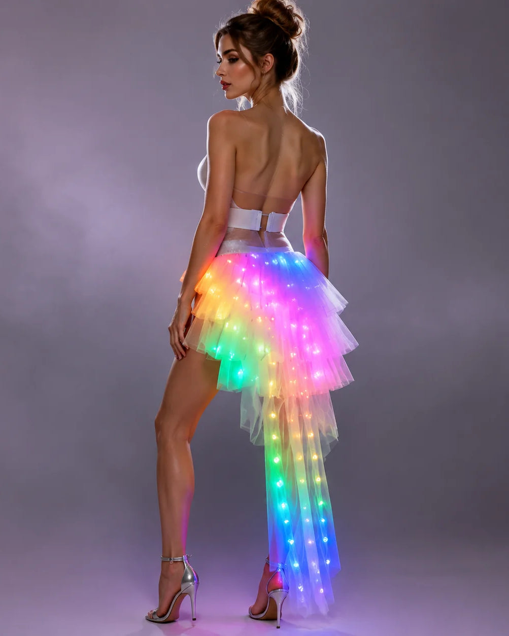 Model wearing a tiered white tulle LED long skirt with vibrant, multi-colored glowing lights and a high-low silhouette.