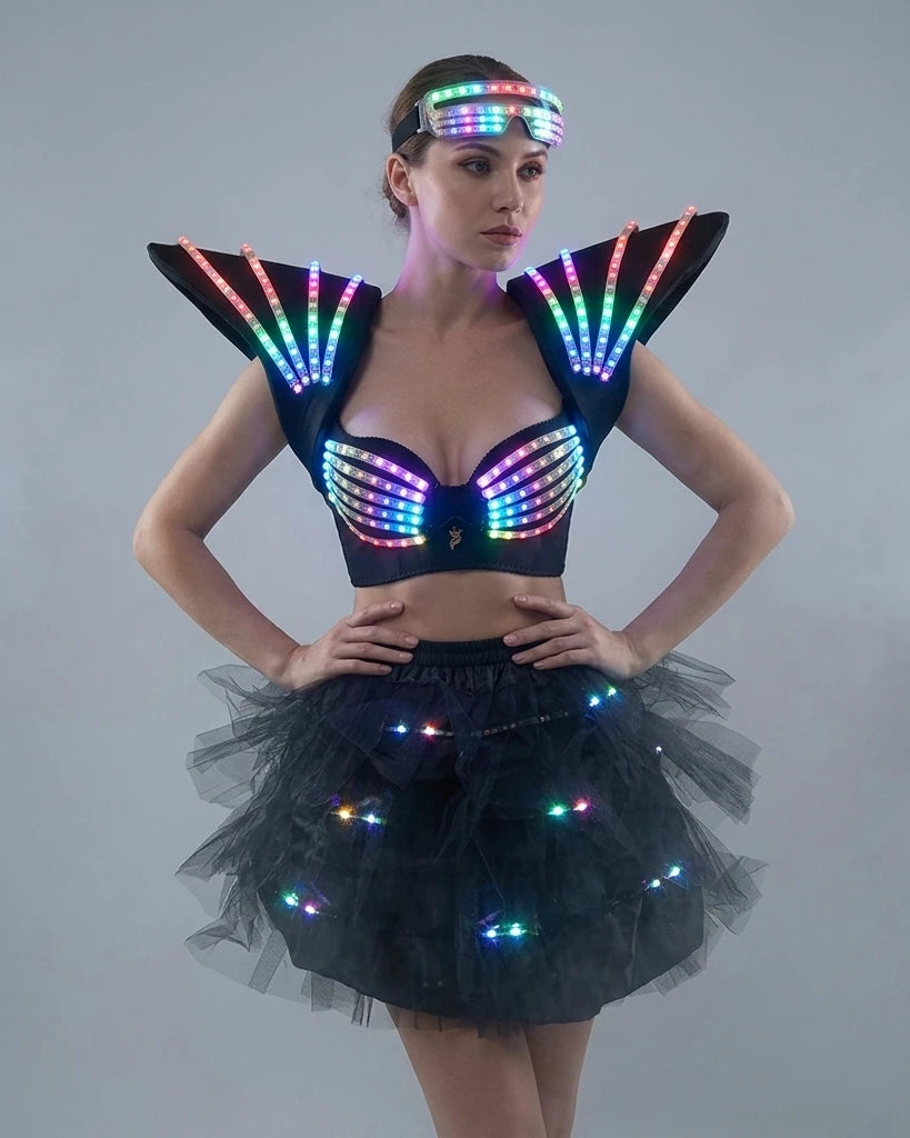 Model wearing a futuristic black LED tutu bra set with glowing shoulder pieces, a light-up bodice, and a matching tulle skirt.