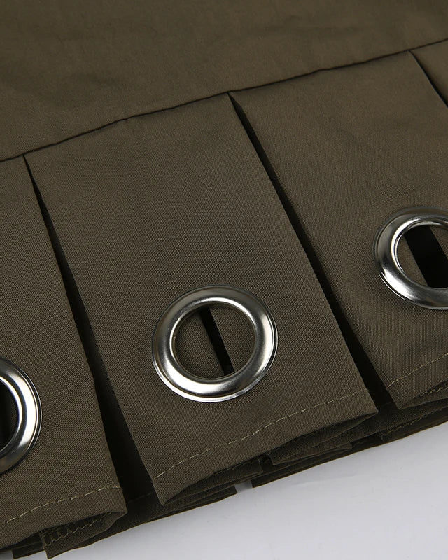 Close-up of the pleated design and metal grommets on the Green Rave Mini Skirt.