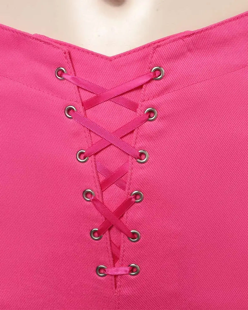 Close-up of a fuchsia spandex top with a central lace-up design featuring silver grommets and matching ribbon.