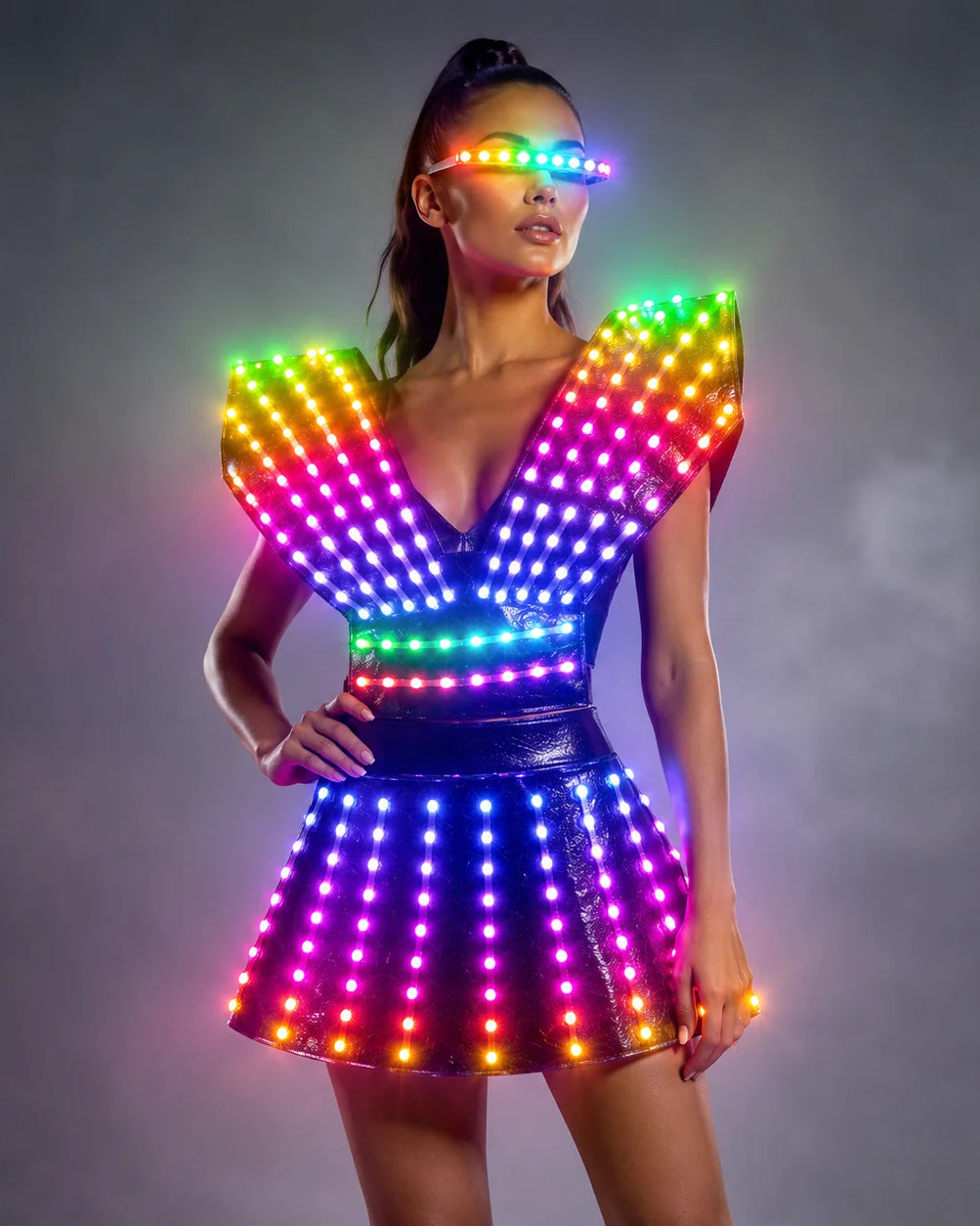 Model wearing a futuristic black LED dress with glowing rainbow lights and matching light-up visor for stage performances.