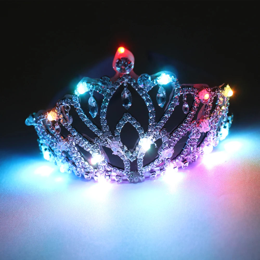 Silver rhinestone tiara featuring intricate filigree patterns and glowing multicolored LED lights against a dark background.