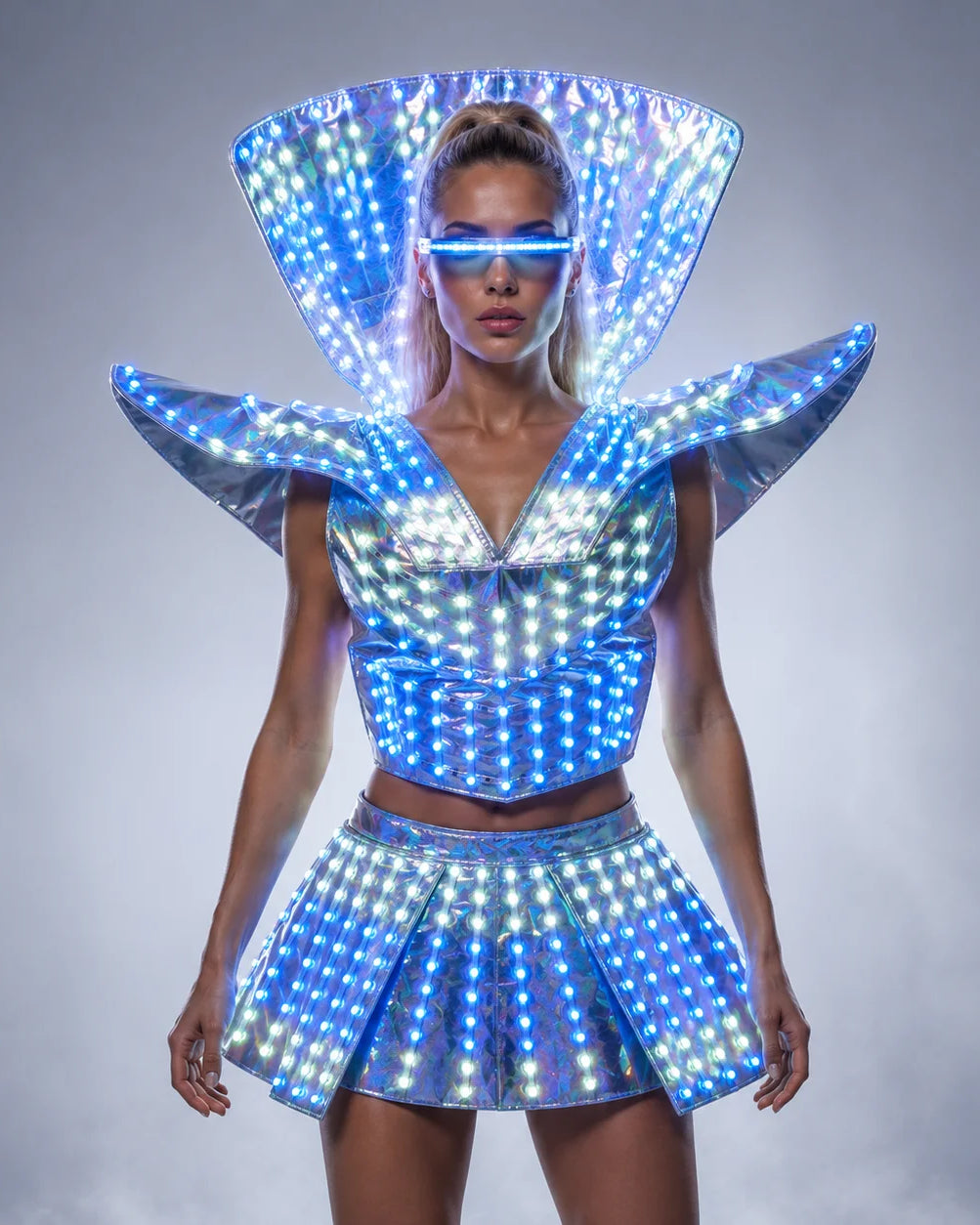 Futuristic LED shoulder armor dress with a metallic finish, glowing blue lights, and matching visor for festival performances.