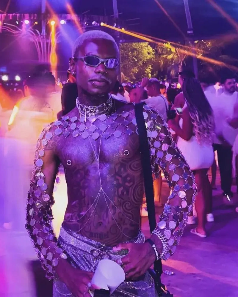 haut court à chaînes métalliques porté lors d'une fête animée, mettant en valeur des disques circulaires métalliques et un style audacieux