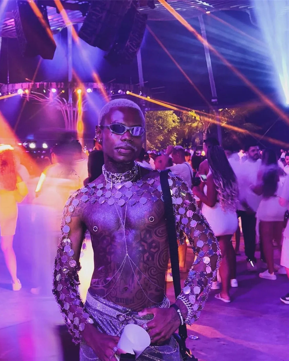 gros plan sur un haut court à disque en chaîne métallique montrant un modèle dans une vie nocturne éclatante avec des lumières disco