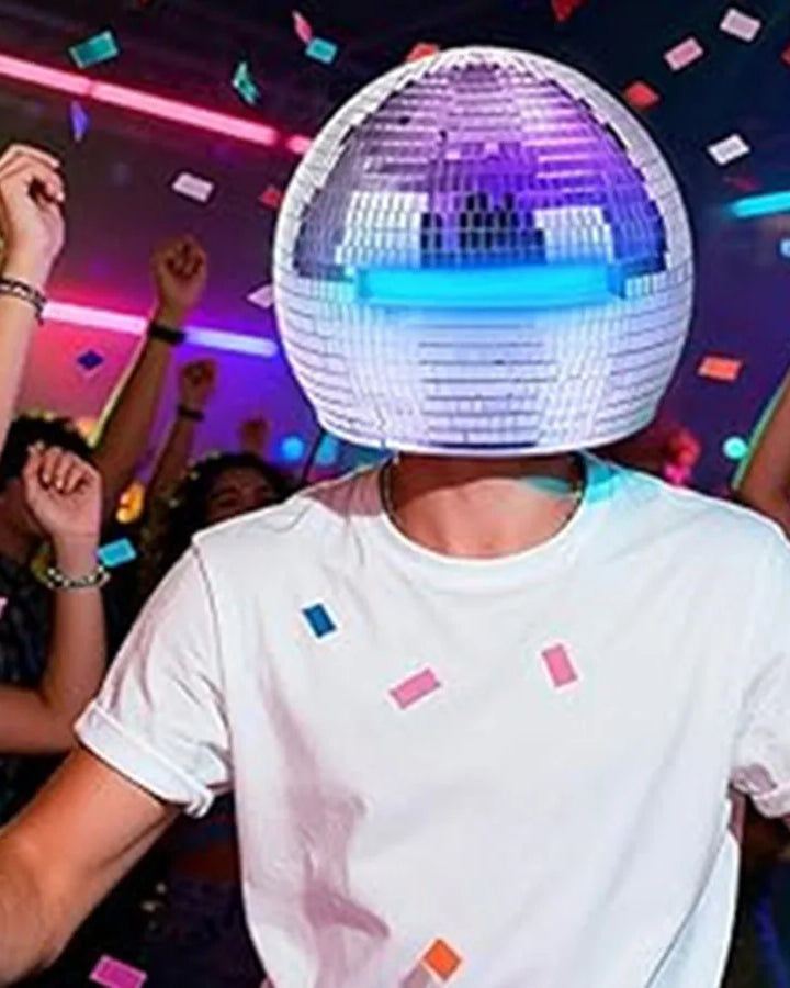 Adult wearing a 40cm Mirror Disco Ball Helmet with built-in blue lights, surrounded by confetti at a party.