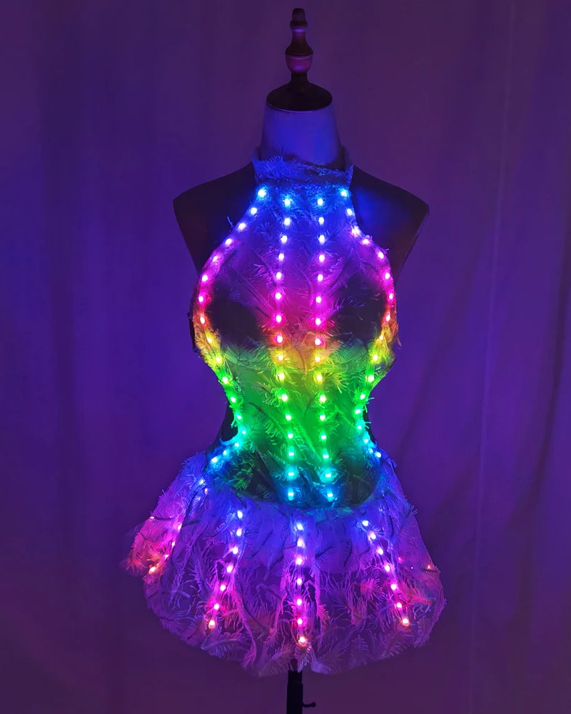 Futuristic white lace dress on a mannequin featuring vibrant, multi-colored LED light strips for a glowing effect.