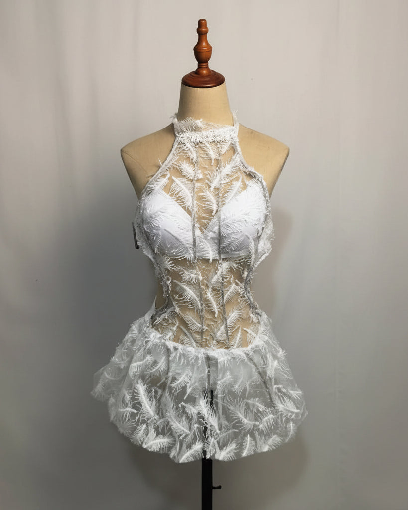 White futuristic LED dress featuring delicate lace, feather-like patterns, and a halter neckline on a mannequin.