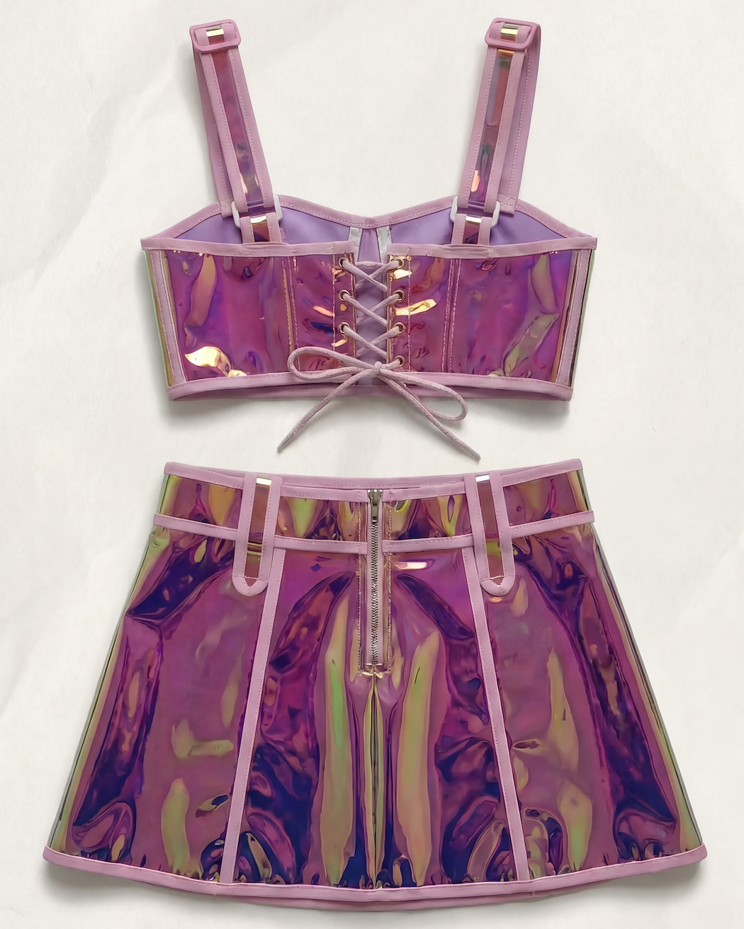Pink reflective polyester crop top with lace-up back and matching mini skirt with front zipper.