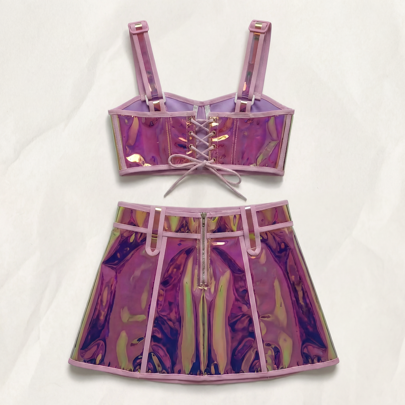 Pink reflective polyester crop top with lace-up back and matching mini skirt with front zipper.