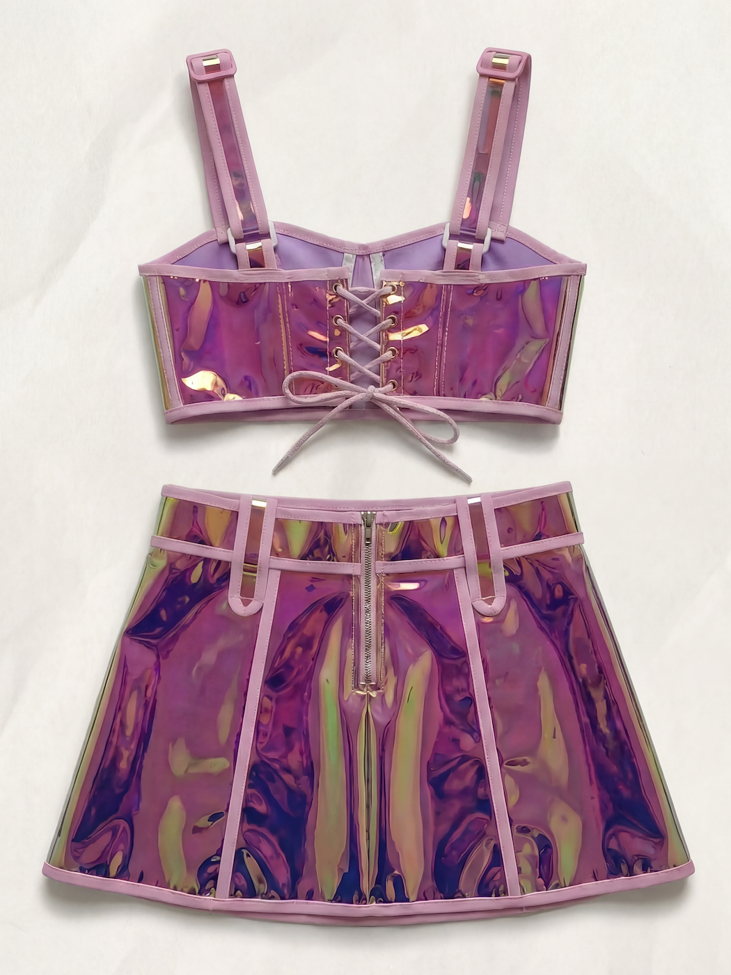 Pink reflective polyester crop top with lace-up back and matching mini skirt with front zipper.