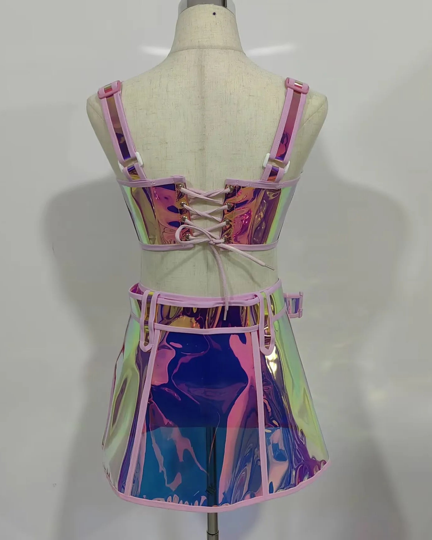 Back view of Pink Reflective Top and Skirt Set showcasing its shiny, vibrant design and lace-up details.