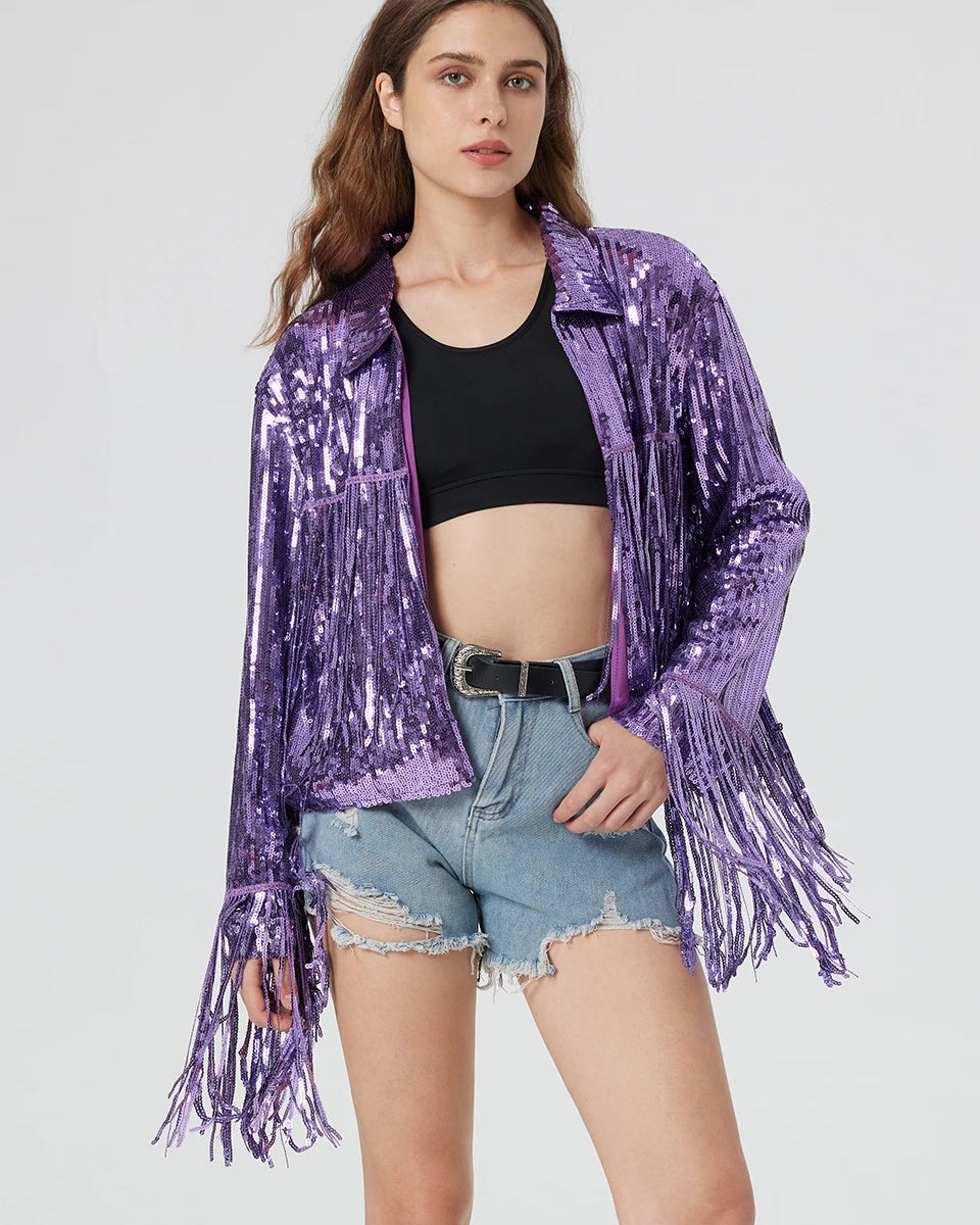Purple metallic sequin jacket featuring long fringe trim on the sleeves and hem, worn over a black top and denim shorts.