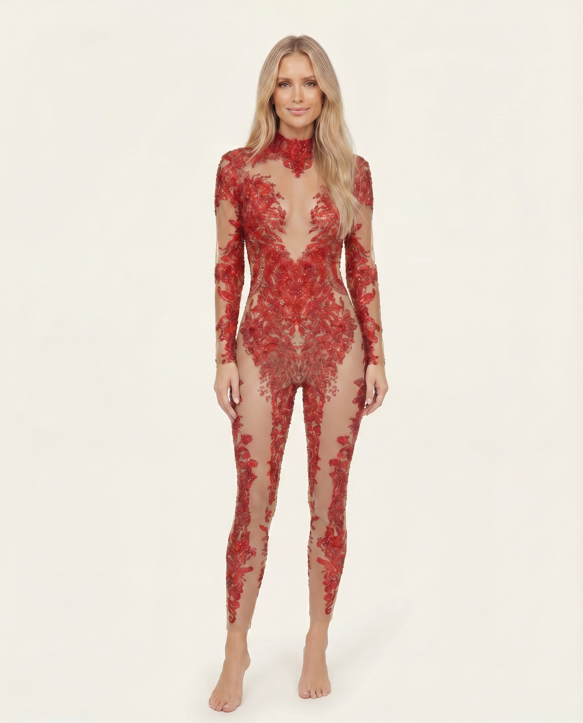 Model wearing a red long-sleeve jumpsuit featuring intricate hand-glued rhinestones and sequins on a sheer spandex base.