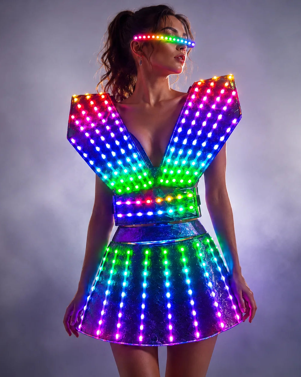Futuristic LED dress with a glowing rainbow light grid, structured shoulders, and matching light-up visor in a smoky setting.