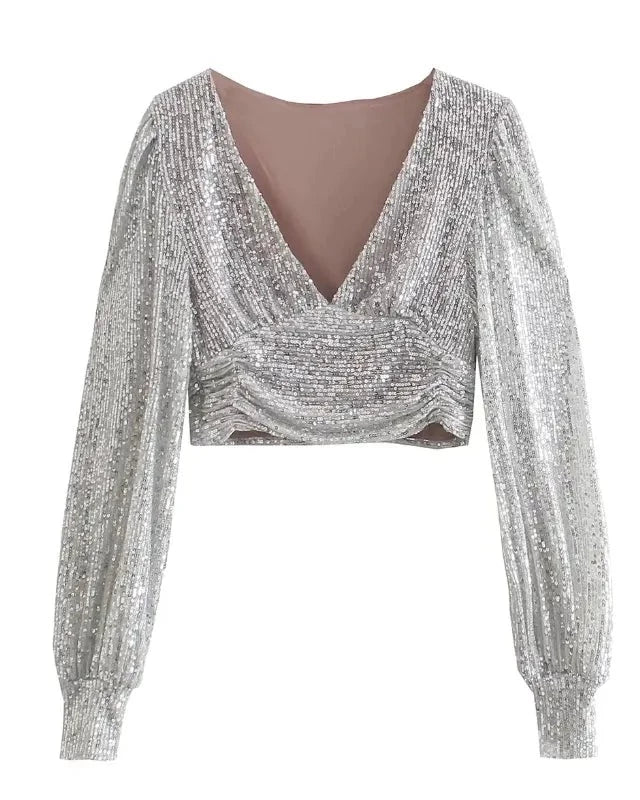 Long Sleeve Sequin Top featuring a shimmery silver design with a plunging neckline and stylish long sleeves.