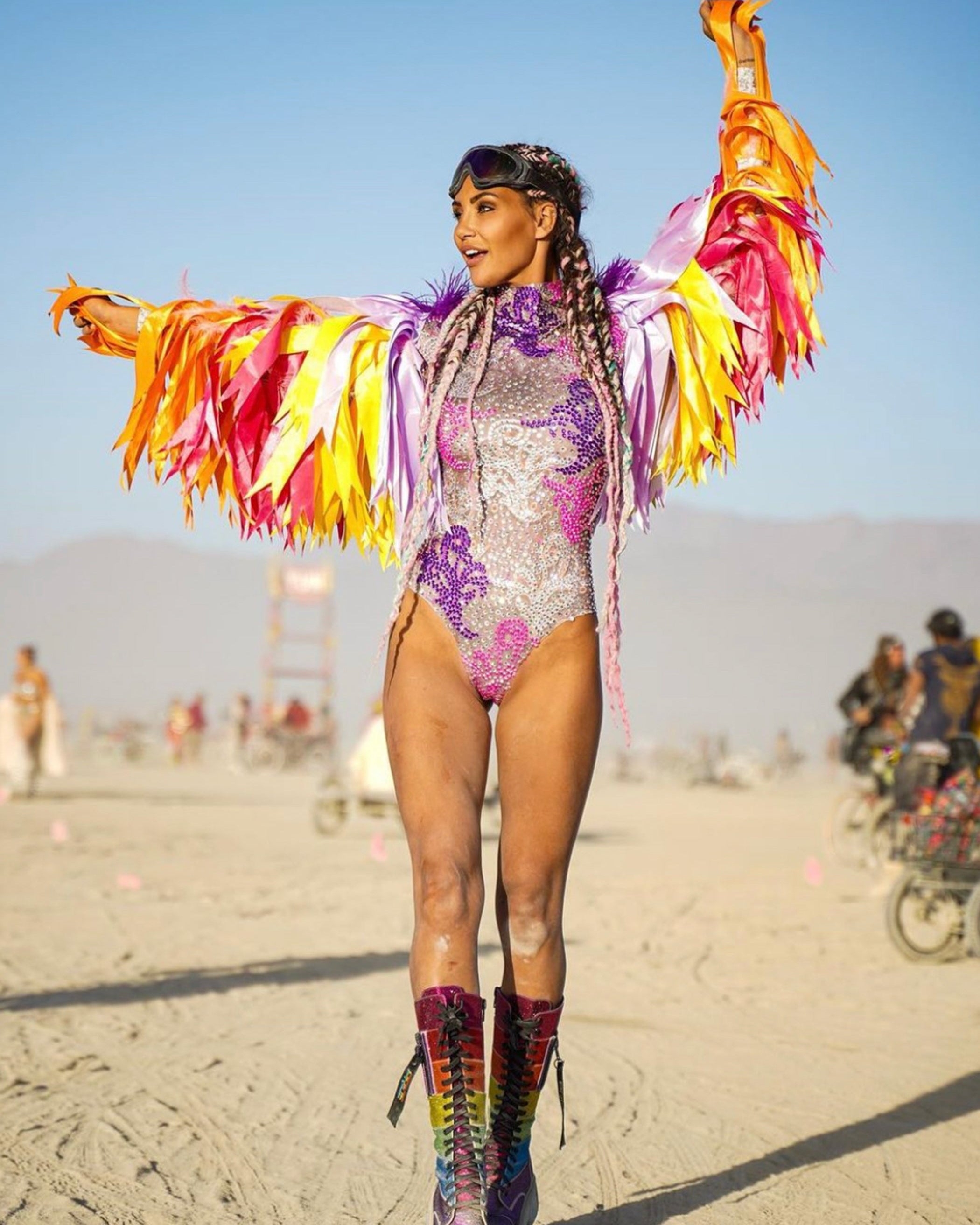 Rhinestones Colorful Bodysuit worn with vibrant feathered wings at a colorful festival.