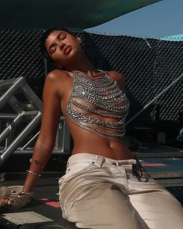 Model wearing a Sequin Metal Chest with metallic chains at a festival, reflecting light.