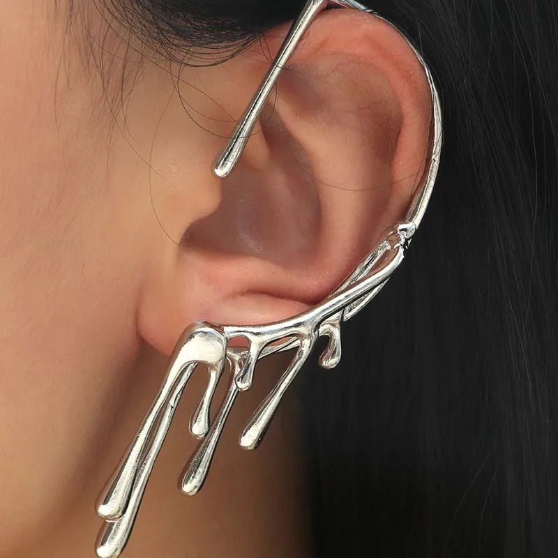 Polsino auricolare completo in metallo argento con design a liquido che gocciola e si scioglie, indossato sull'orecchio sinistro.