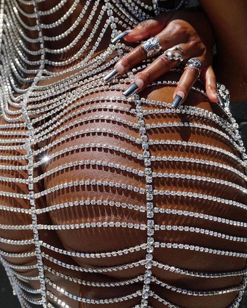 Primer plano del Vestido Plateado Brillante con pedrería que muestra detalles de pedrería y un diseño que realza las curvas.