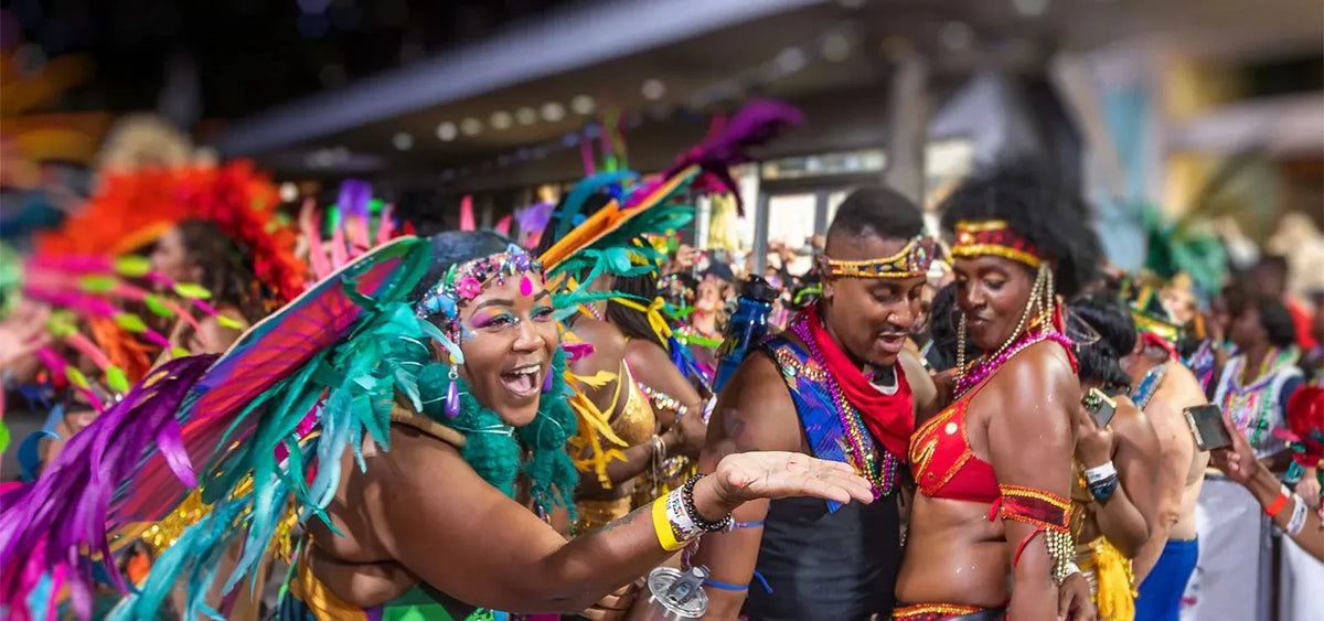 Joyful revelers in vibrant feathered costumes at Key West's Fantasy Fest parade.