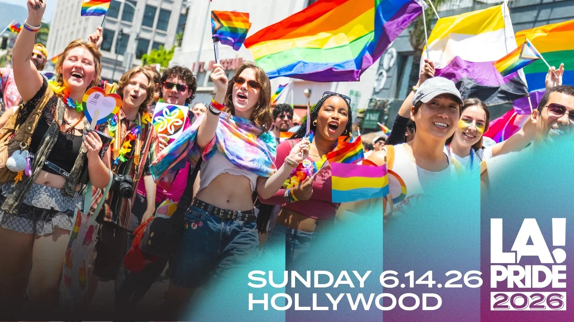 Joyful crowd waving rainbow and Pride flags at a sunny LA Pride parade.