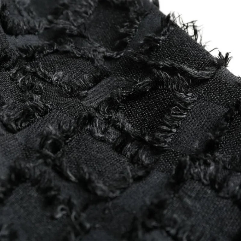 Close-up of black textured polyester-cotton blend fabric with fringe detailing from the Lucian Boho Fringe Vest.