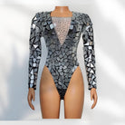 Mannequin wearing a patterned long-sleeve top with geometric design on a white background