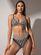Model wearing an iridescent acrylic gem halter top and matching tassel chain skirt set.