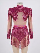 Body in paillettes rosa con ventre trasparente, spalle strutturate e gonna con frange abbinata.