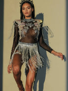 Impresionante body de festival con borlas y pedrería que presenta pedrería, lentejuelas y borlas fluidas.