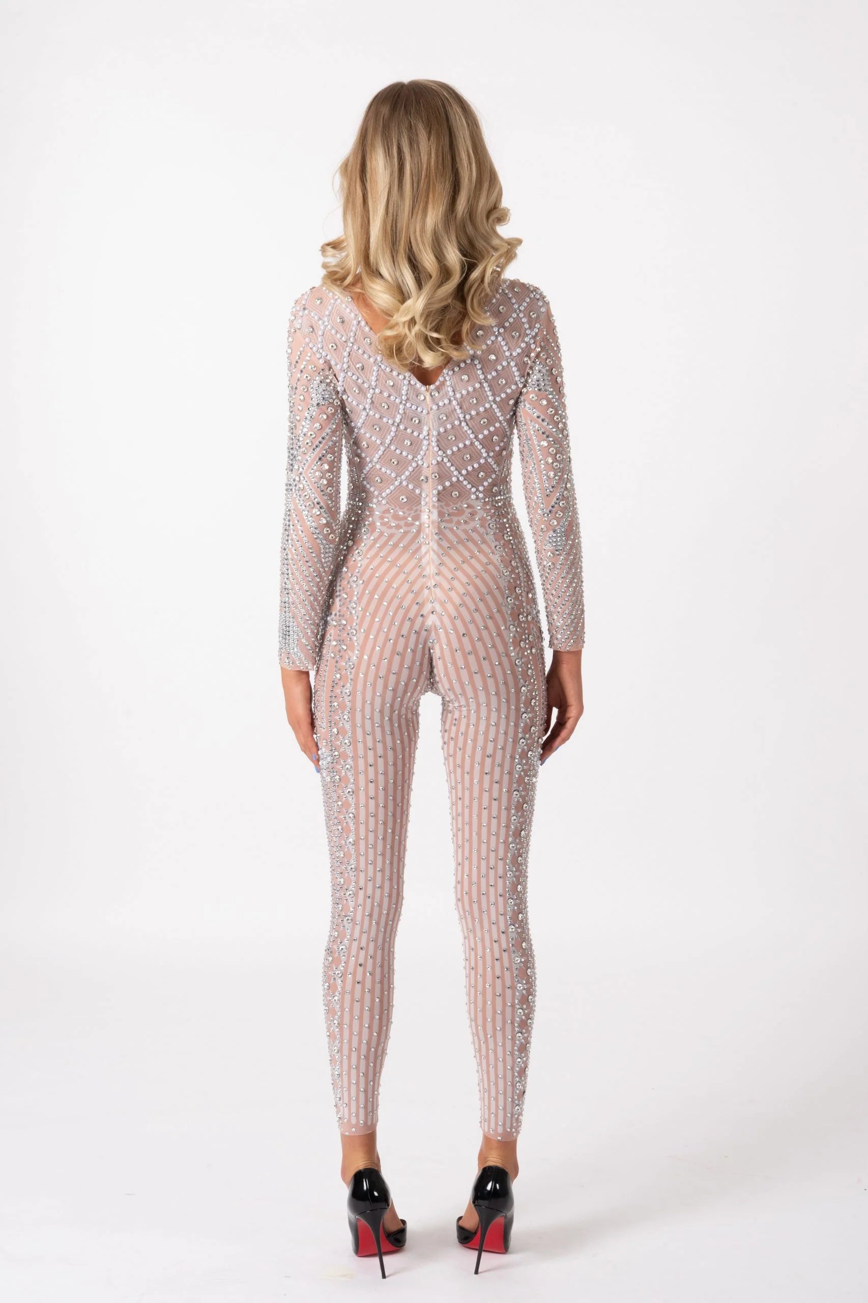 Back view of a nude, long-sleeve jumpsuit featuring hand-glued rhinestones in a vertical striped pattern on stretch fabric.