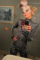 Zwarte jumpsuit met witte parels gedragen door een persoon, met een strak ontwerp en elegante parels.