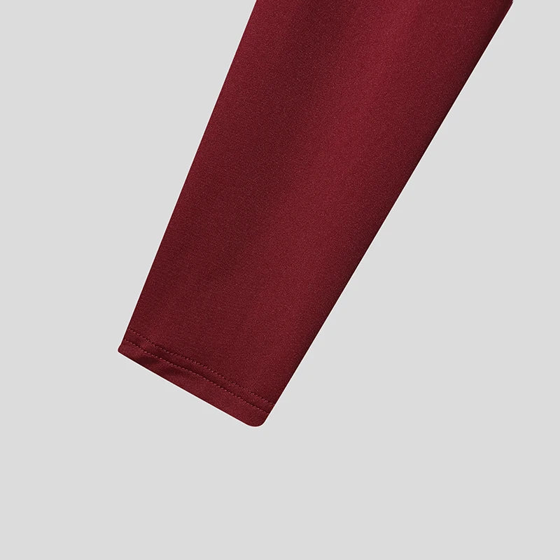 close-up of tassel fringe crop top sleeve in burgundy stretchy fabric