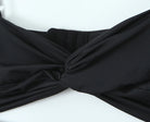 Haut froncé dos nu présentant un élégant design de nœud en tissu noir très extensible.