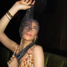 Mujer con un pañuelo para la cabeza negro con pedrería, mostrando su diseño brillante y estilo elegante.