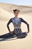 Combinaison noire ornée de strass avec des paillettes sur le modèle, parfaite pour les festivals et les moments de mode audacieux.