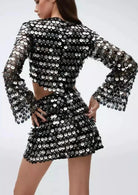 Zwarte mini feestjurk met pailletten en uitsparingen, met schitterende pailletten en stijlvolle cut-outs.