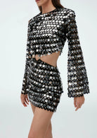 Zwarte mini feestjurk met pailletten en opengewerkte details, voorzien van schitterende pailletten en stijlvolle uitsnijdingen.