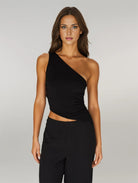 Modelo vistiendo Top sin espalda con tirantes, con un diseño asimétrico y tela elegante para conjuntos con estilo.