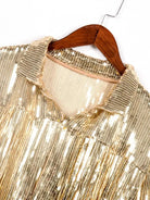 Detail der goldenen Paillettenjacke mit Quasten